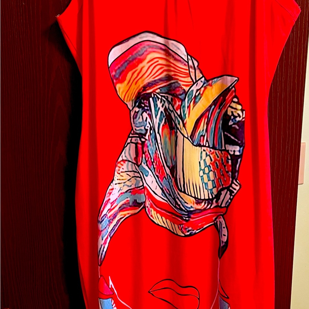 Orange body con dress with colorful motif of artist face and scarf on front.